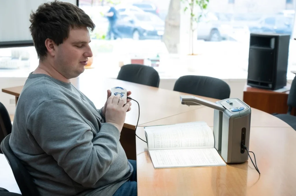 Disabled man sitting on a chair and reading something