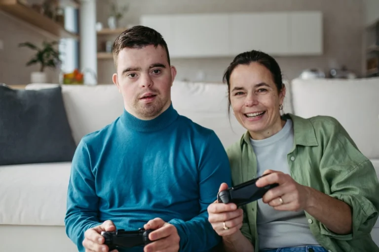 Disabled man and her support worker playing video games