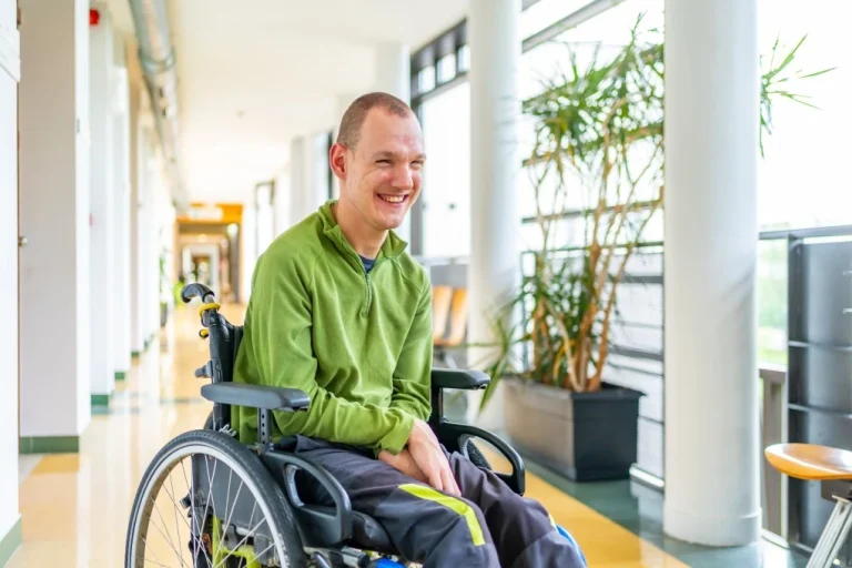 Disabled man smiling and sitting in his wheelchair