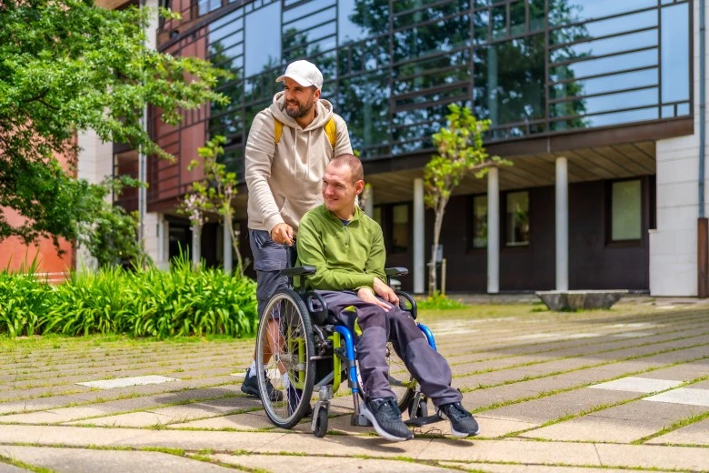 Disabled man in the park with his support worker
